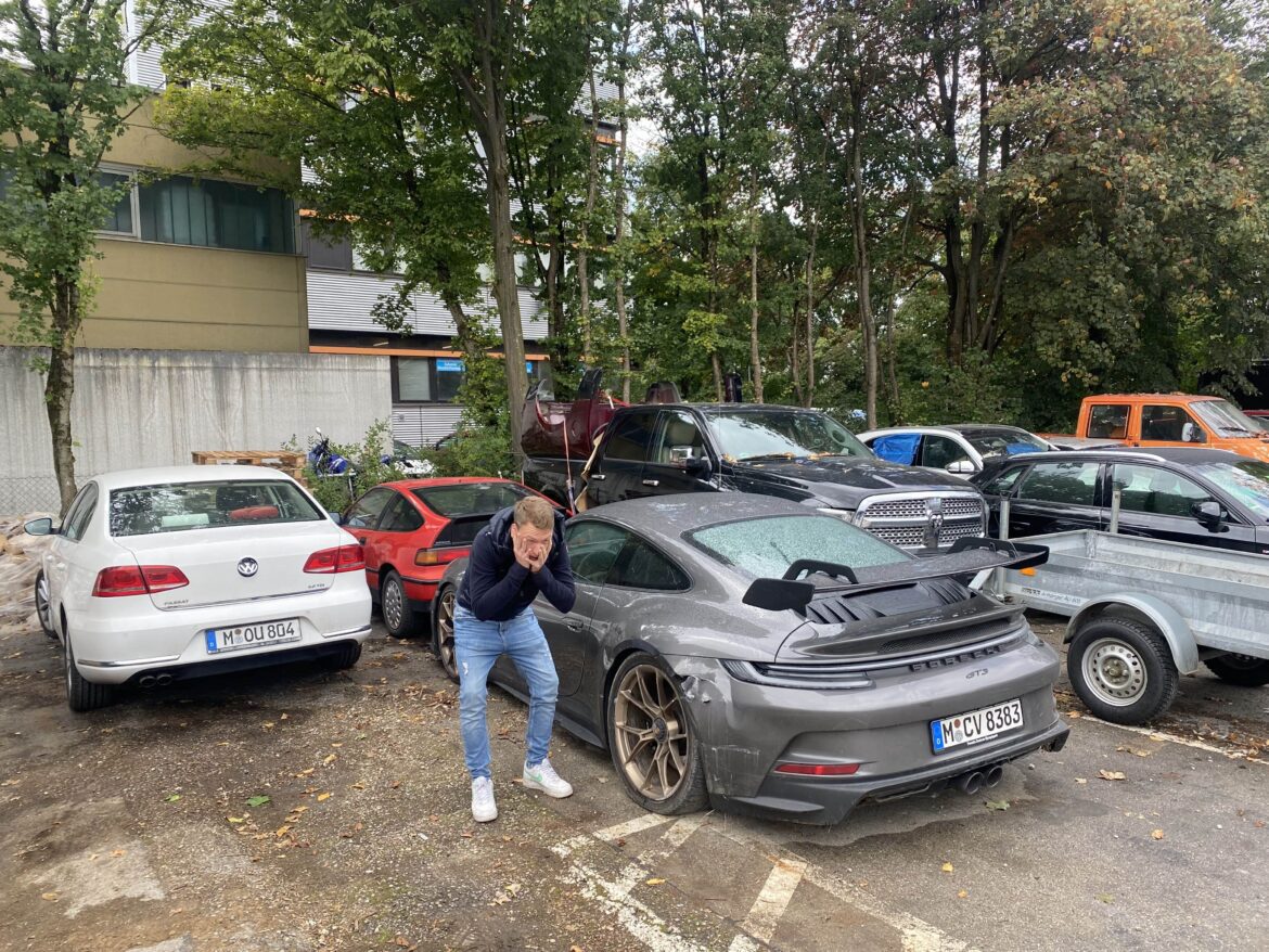 CarVia-Gründer Joschka Reik schlägt vor einem kaputten Porsche GT3 die Hände über dem Kopf zusammen.